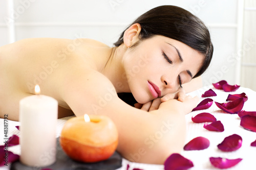 Beautiful woman relaxing sleeping naked during massage in spa