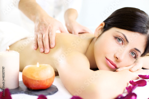 Young woman getting back massage in luxury spa