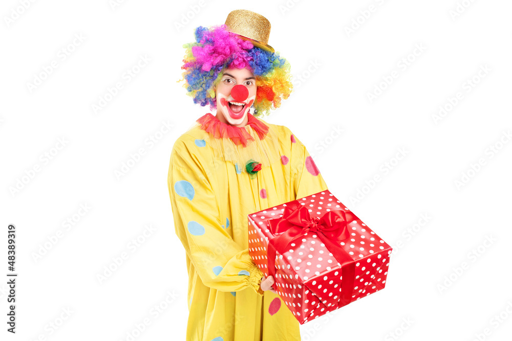 A happy male clown holding a red present A happy male clown holding a red present