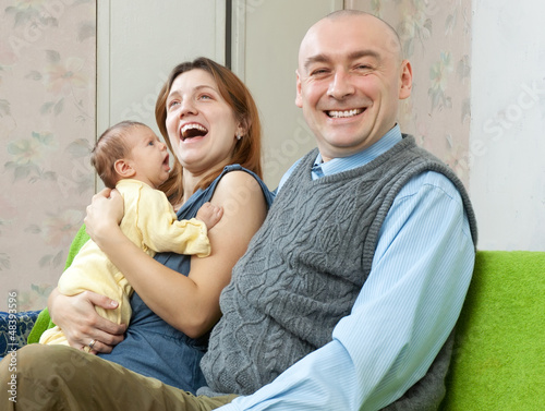 laughing parents with newborn baby