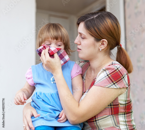  woman wipes snivels  daughter photo