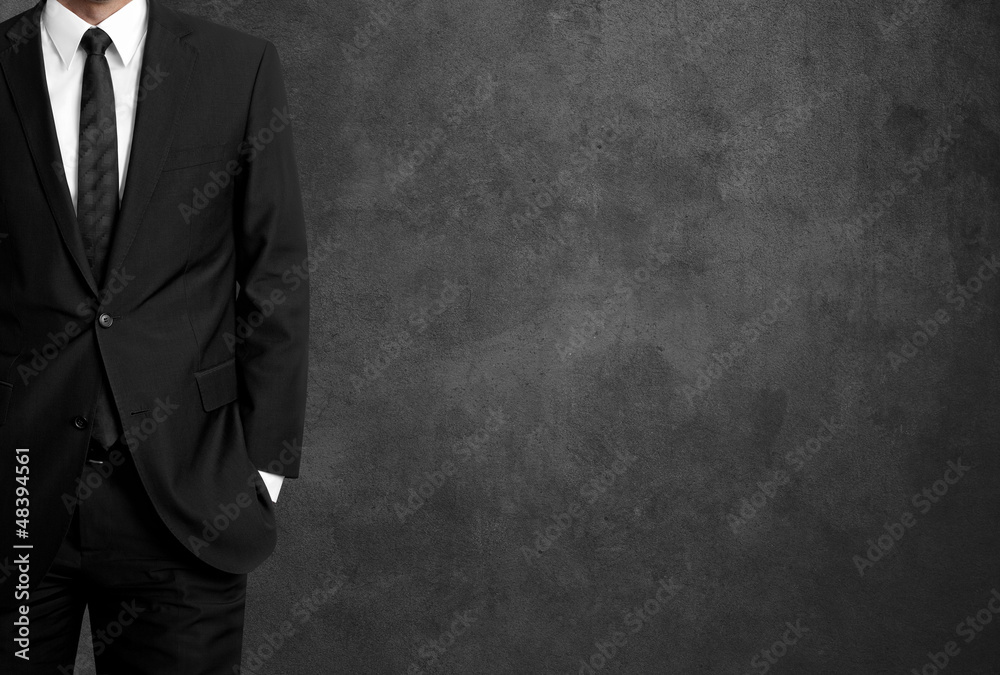 man in suit on a concrete wall background man in suit on a concrete wall background