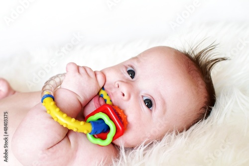The baby plays a rattle (3,5 months)