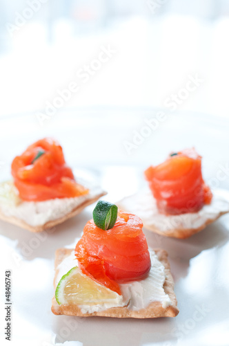 Canapes with smoked salmon and cream cheese on white plate