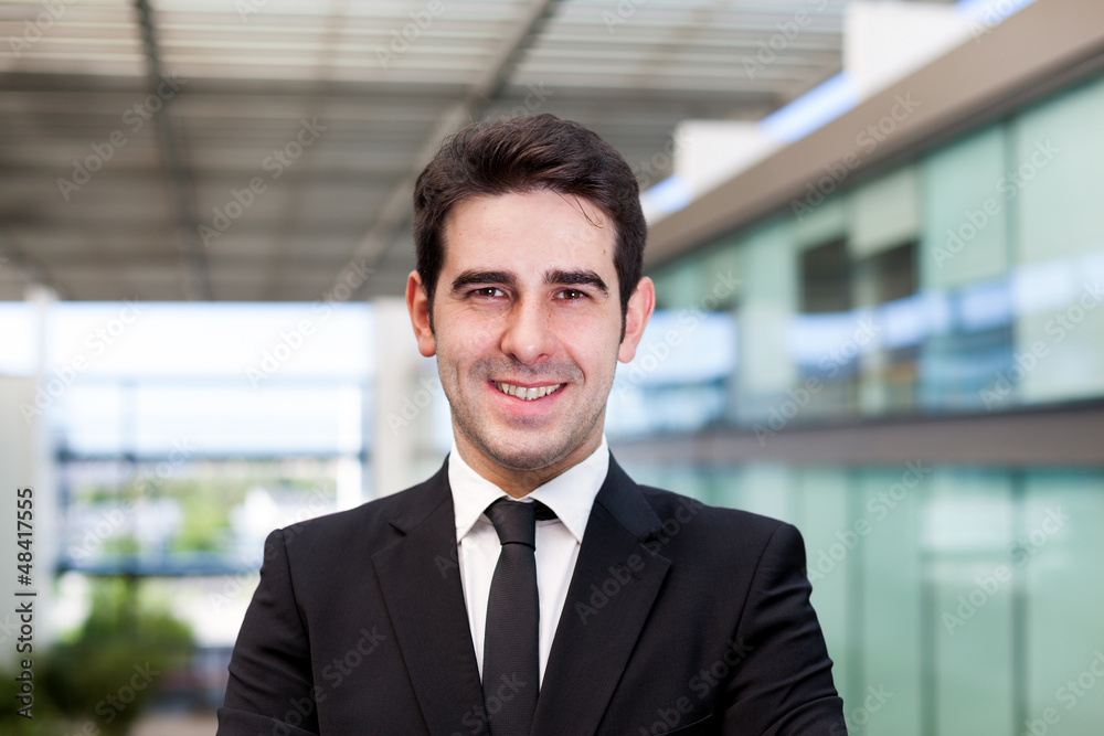 Portrait of a smiling young business man at modern office