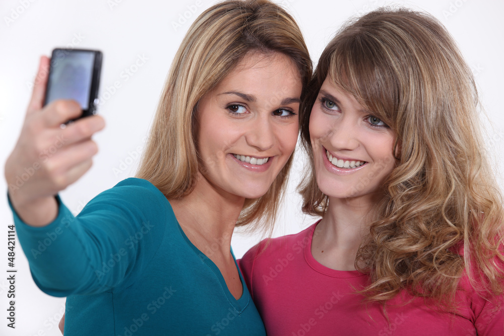 Two girls taking a picture of themselves. Two girls taking a picture of themselves.