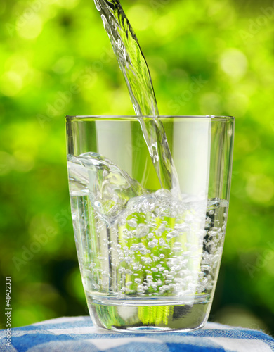 Glass of water on nature background