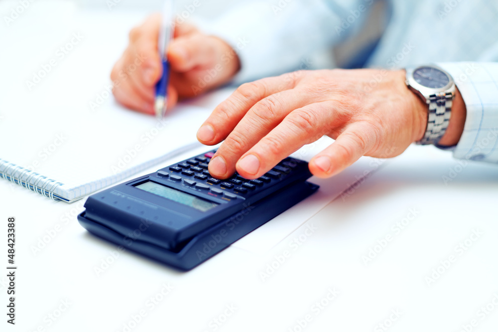 Closeup of a businessman calculating Closeup of a businessman calculating