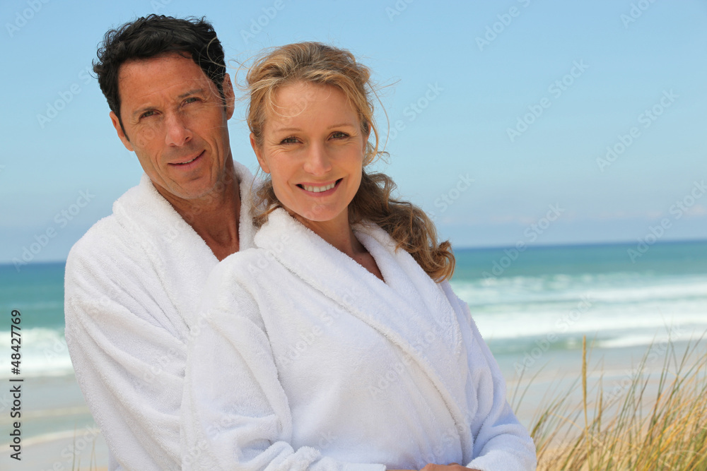 Obraz premium couple in robes on the beach