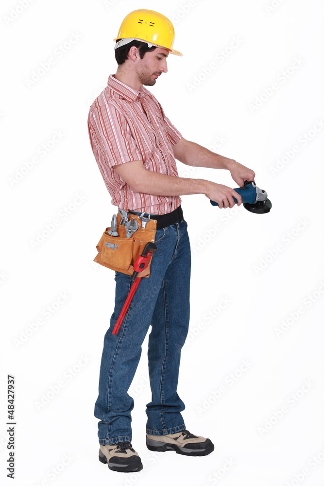 Manual worker stood with angle grinder Manual worker stood with angle grinder