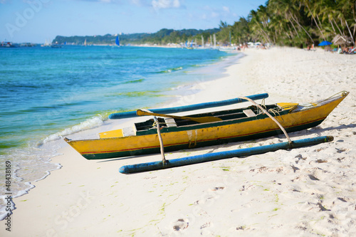 Old wooden bangka boat on white sand beach at Boracay, Philippin photo