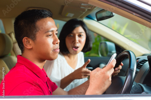Asian man texting while driving © Kzenon