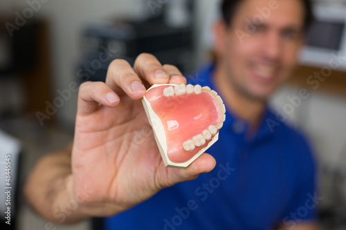 Dental technician presenting dental prosthesis photo