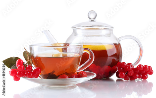 Glass teapot and cup with black viburnum tea isolated on white