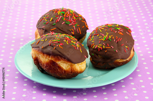 Tasty donuts on color plate on color background