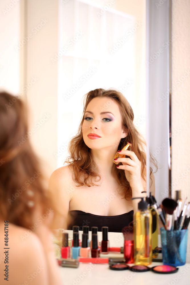 Portrait of attractive woman applying parfume Portrait of attractive woman applying parfume