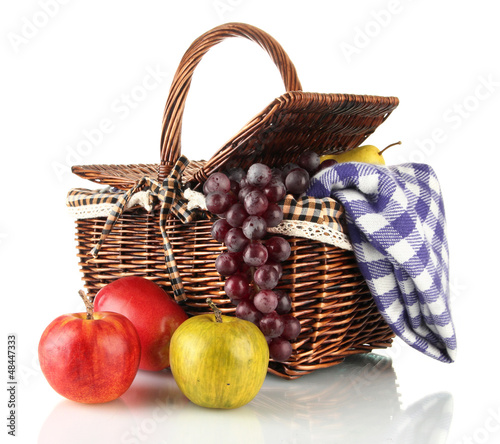 Picnic basket with fruits and blanket isolated on white