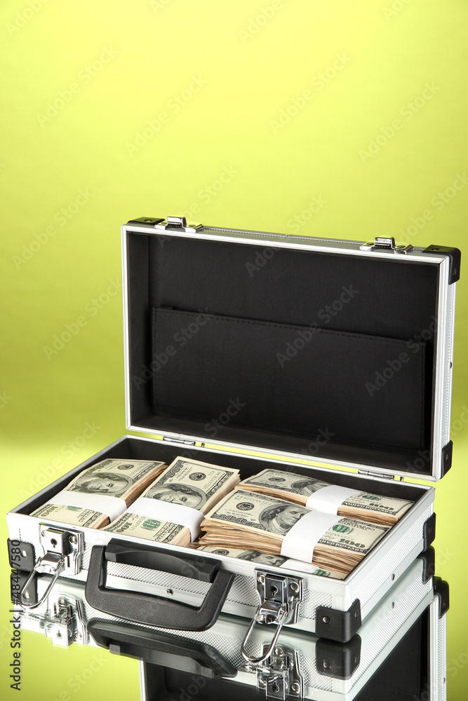 Suitcase with 100 dollar bills on green background Suitcase with 100 dollar bills on green background