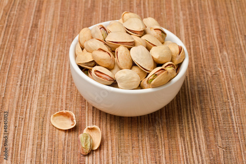 Pistachios nuts in bowl over tablecloth