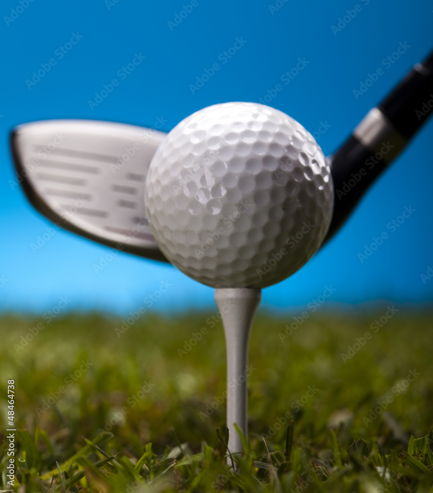 Golf ball on green grass over a blue background Golf ball on green grass over a blue background