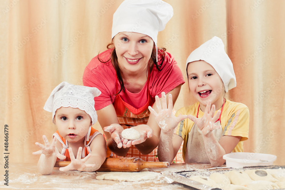Mother with two daughters baking bread. Mother with two daughters baking bread.