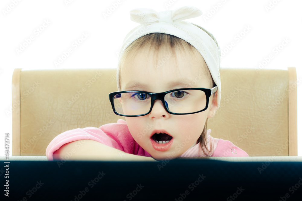 Cute baby with glasses looking into the laptop Cute baby with glasses looking into the laptop
