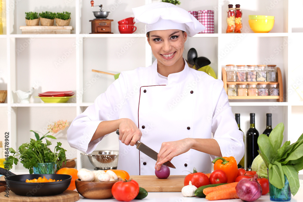 Young woman chef cooking in kitchen Young woman chef cooking in kitchen