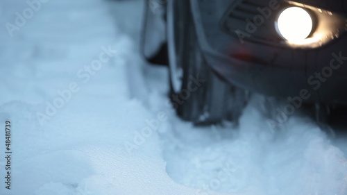 Winter tyres close up on a car in snow going back