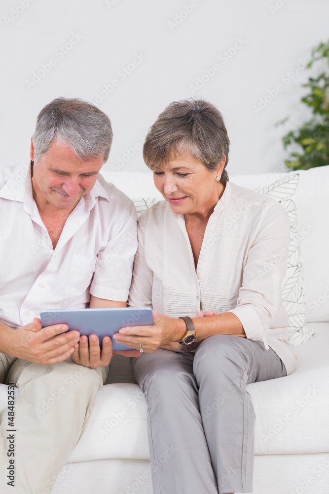 Old couple looking tablet pc with smiling