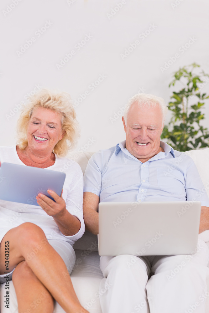 Old couple using a laptop and the tablet