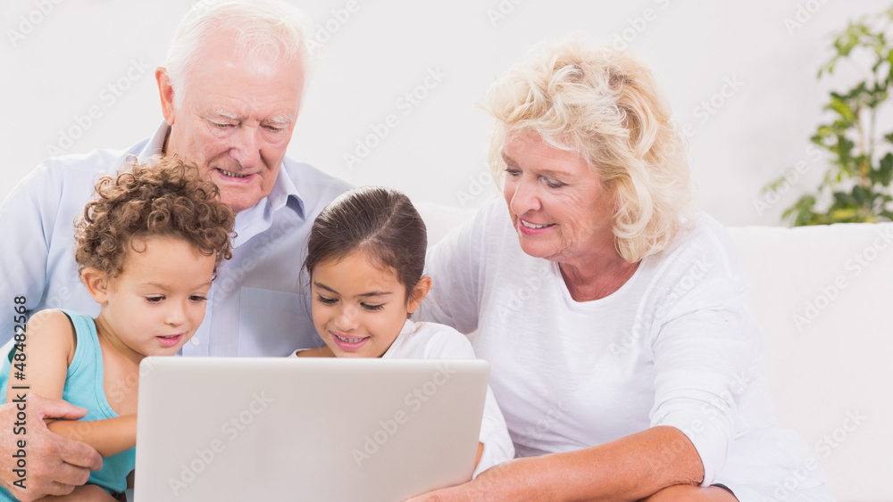 Grandparents with children using a laptop Grandparents with children using a laptop