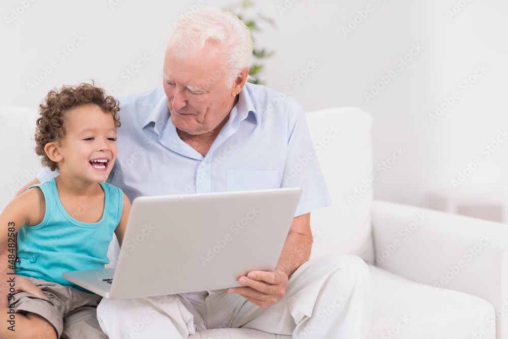 Grandfather and his grandson watching a laptop screen