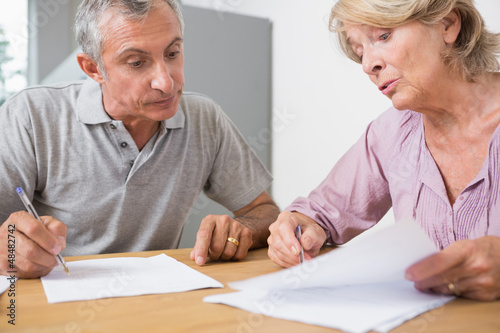 Mature couple discussing with documents