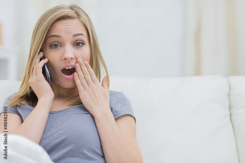 Portrait of casual shocked woman using cellphone at home Portrait of casual shocked woman using cellphone at home