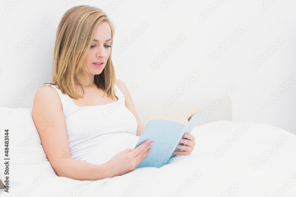 Young reading book in bed Young reading book in bed