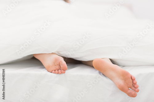 Woman's feet sticking out of blanket