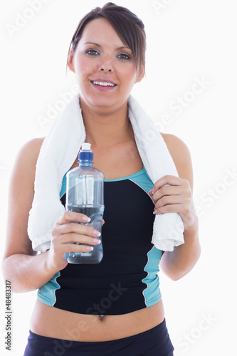 Portrait of woman in sportswear holding towel around neck and wa