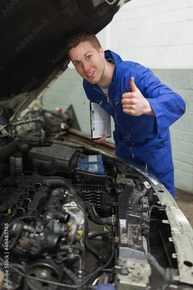 Confident mechanic gesturing thumbs up Confident mechanic gesturing thumbs up
