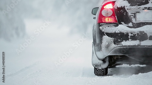 Car on winter road with smoke from exhaust pipe