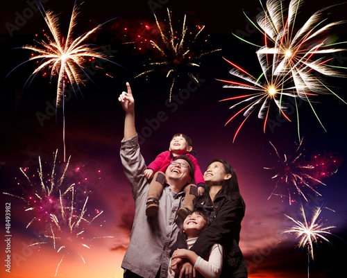 Canvas Print happy family looking fireworks in the evening sky