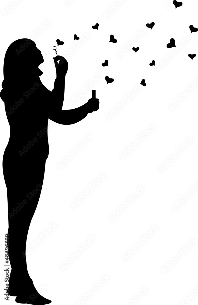 Young girl blowing soap bubbles in heart shaped silhouette