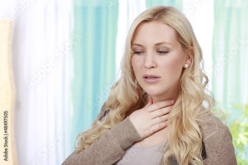 Hübsche Frau mit Schluckbeschwerden und Halsschmerzen