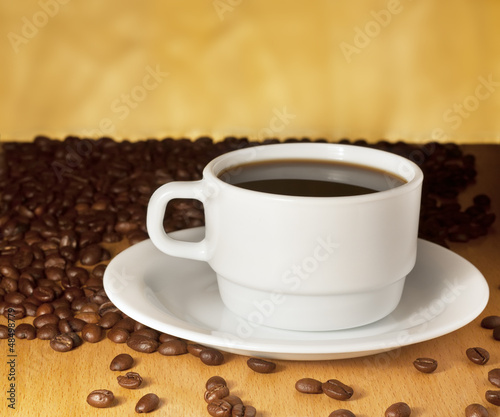 White cup of coffee on a yellow background