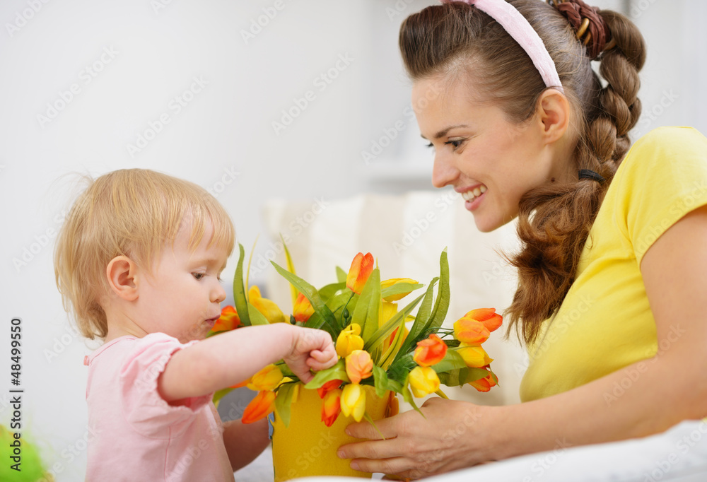 Happy mother and baby making decoration with bouquet of tulips Happy mother and baby making decoration with bouquet of tulips