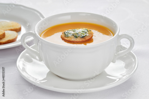 Close-up of roasted-pumpkin soup in a white bowl.