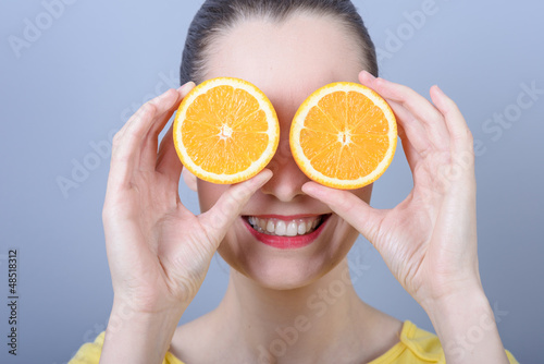 Young brunette woman with oranges in her hands