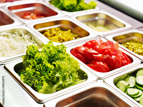 Tray with  food  on showcase at cafeteria
