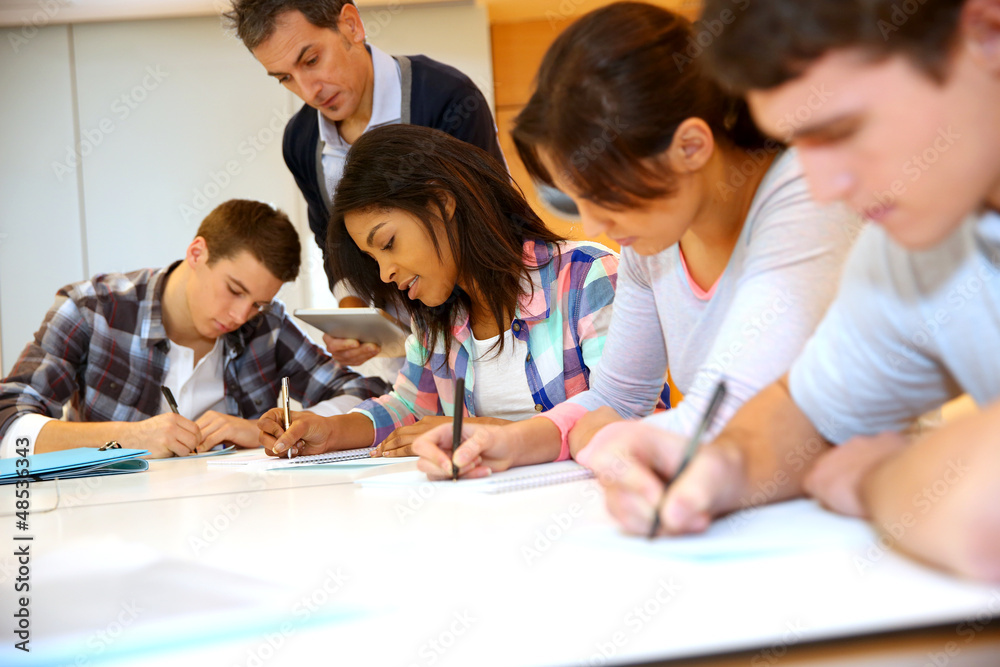 Group of teenagers in class writing an exam