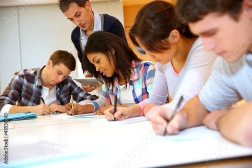 Group of teenagers in class writing an exam