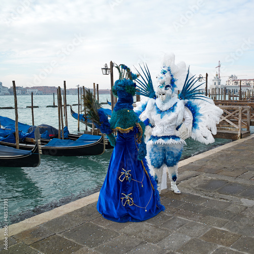 Person in Venetian costume attends Carnival of Venice.